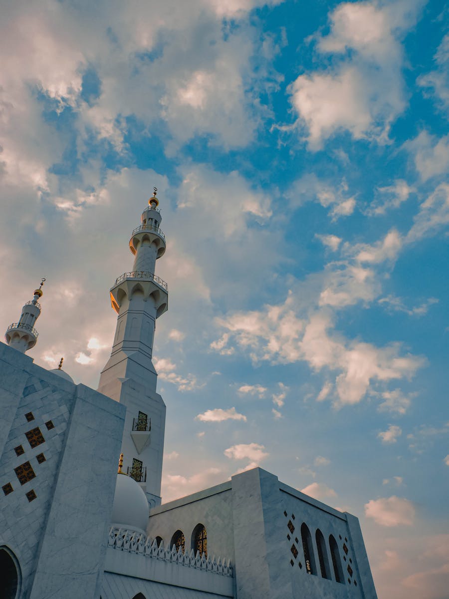 Captivating view of a mosque with intricate architecture reaching into a vibrant blue sky.